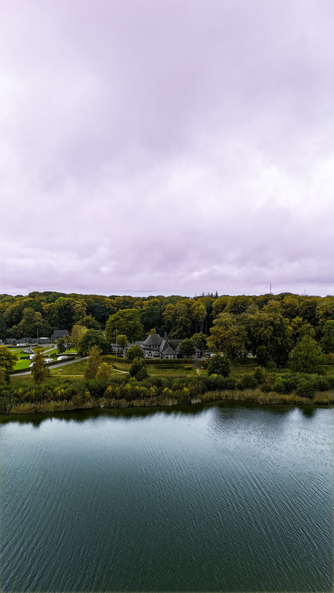 Dronefoto af herregård ved sø